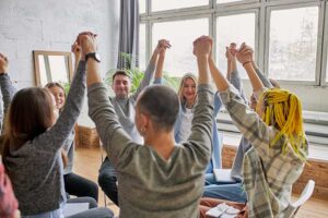people raise their arms in a group session in a benzo addiction treatment program