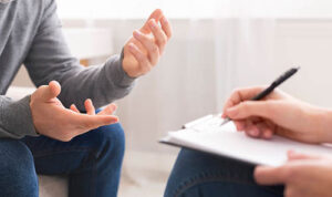 shot of hands of therapist and client in a PTSD treatment session