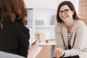 a woman talks with a therapist about the benefits of women's rehab